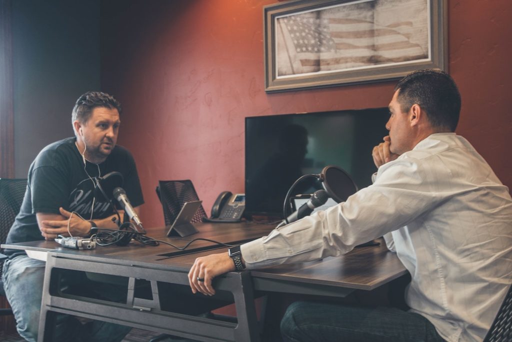 Productive conflict helps provide better understanding. Two men sitting at table talking. 