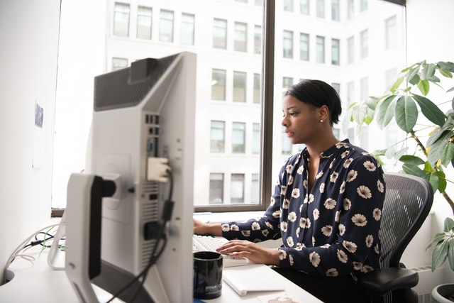 woman typing at computer-meetings that could have been an email